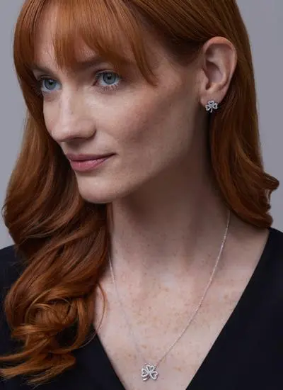 Red haired model wearing Shamrock Stud Earrings Adorned With Swarovski Crystals with matching pendant 